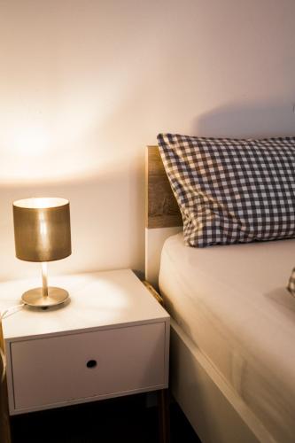 a bed with a nightstand with a lamp on it at Zur grossen Tanne in Bühl