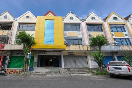 a building with a yellow and blue building at Good Sleep Balikpapan Mitra RedDoorz in Balikpapan