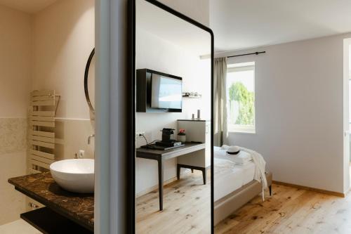uma casa de banho com um lavatório e um espelho em Ansitz am Eck by Hotel Pernhof em Termeno