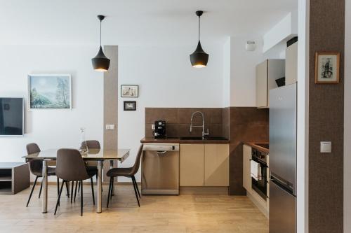 een keuken en eetkamer met een tafel en stoelen bij Garden - Quiet Apartment in the City Center in Krakau