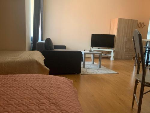 ein Wohnzimmer mit einem Tisch und einem TV in der Unterkunft Perlos apartamentai 13 butas in Birštonas