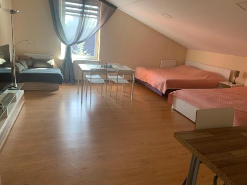 1 Schlafzimmer mit 2 Betten, einem Tisch und Stühlen in der Unterkunft Perla 12 butas in Birštonas