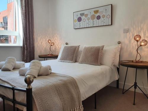 a bedroom with a bed and two tables and a window at Cooperage Court by Cliftonvalley Apartments in Bristol