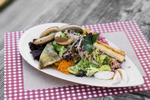 a plate of food with a salad and a sandwich at Zur grossen Tanne in Bühl