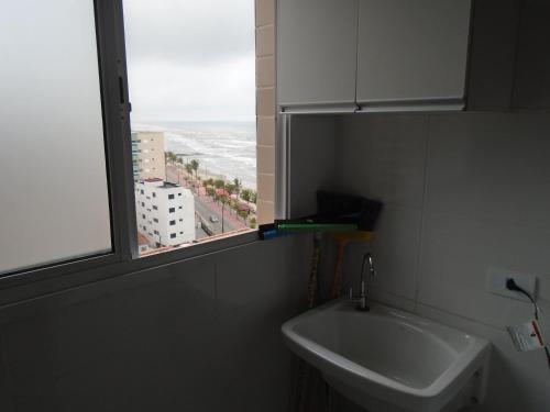 a bathroom with a sink and a window at Apartamento em Mongaguá, Frente ao Mar in Mongaguá