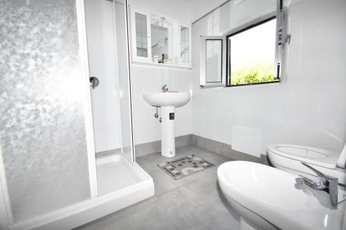 a white bathroom with a sink and a toilet at Casa del Menegotto in Rapallo