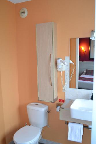 a bathroom with a toilet and a sink and a mirror at The Originals Boutique, Hôtel Les Quatre Salines, Le Mont Saint-Michel Sud in Roz-sur-Couesnon