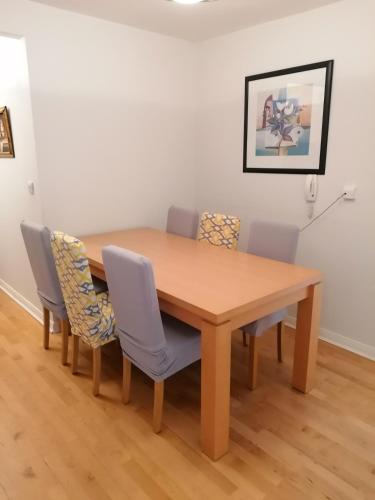 a dining room table with chairs and a wooden table at 4 Clifden Court in Clifden