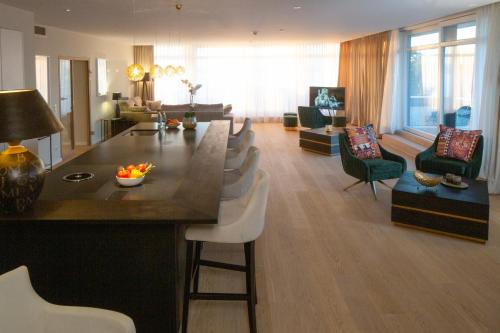a living room with a kitchen and a living room with chairs at Intermar Hotel & Apartments in Glücksburg