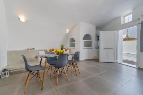 a kitchen and dining room with a table and chairs at Cally Cave House in Fira