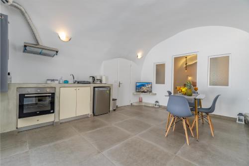 a kitchen and dining room with a table and chairs at Cally Cave House in Fira