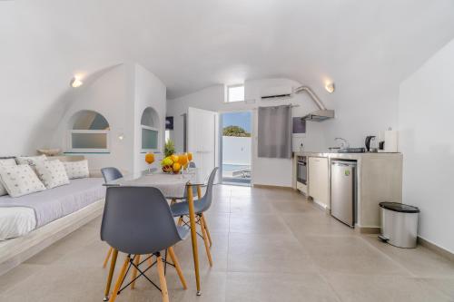 a living room and kitchen with a table and chairs at Cally Cave House in Fira