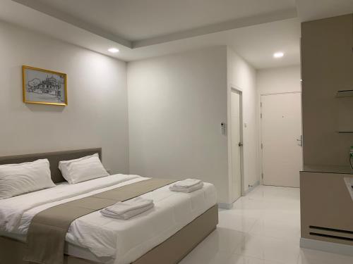 a bedroom with a large bed with towels on it at Icare Residence & Hotel in Bangkok