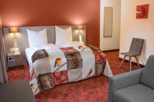 ein Hotelzimmer mit einem Bett und einem Stuhl in der Unterkunft Hotel zum Fischer in Dachau