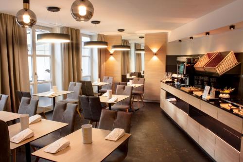 a restaurant with tables and chairs and a counter at Hotel zum Fischer in Dachau