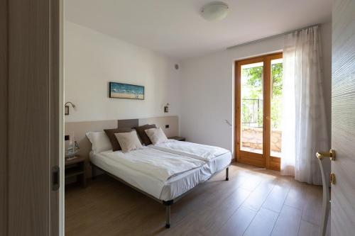 ein Schlafzimmer mit einem Bett und einer Glasschiebetür in der Unterkunft Holiday House Margherita in Brenzone sul Garda