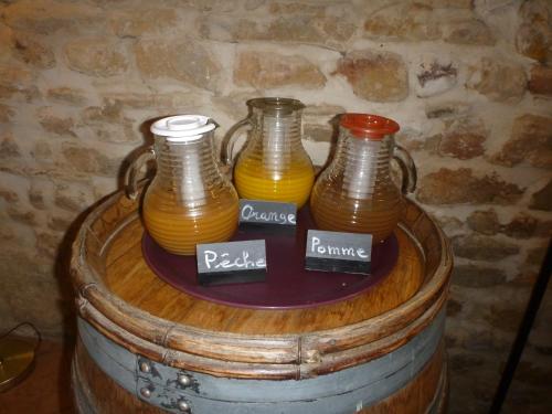 a table with three vases on top of a barrel at Logis Hôtel La Bastide Saint Bach in Suze-la-Rousse