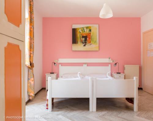 een slaapkamer met een wit bed en een roze muur bij Centro Ferie Salvatore in San Felice Circeo