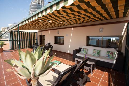 a patio with a couch and a table and chairs at Apartamentos María Cristina Beach in Benidorm
