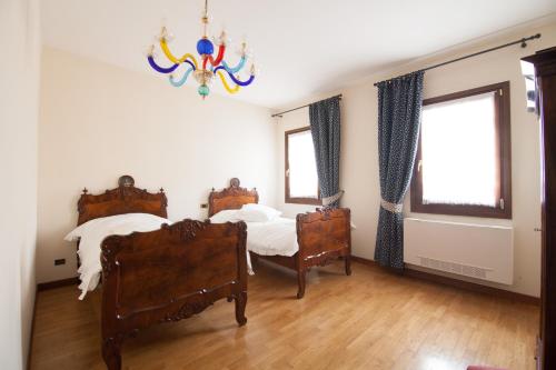 1 Schlafzimmer mit 2 Betten und einem Kronleuchter in der Unterkunft Agriturismo Gazza Ladra in Noventa di Piave