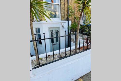 a black fence in front of a house at Stunning, peaceful entire flat in the centre of Wimbledon in London