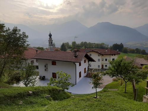a white building with a clock tower in the distance at Villetta Casale in Comano Terme