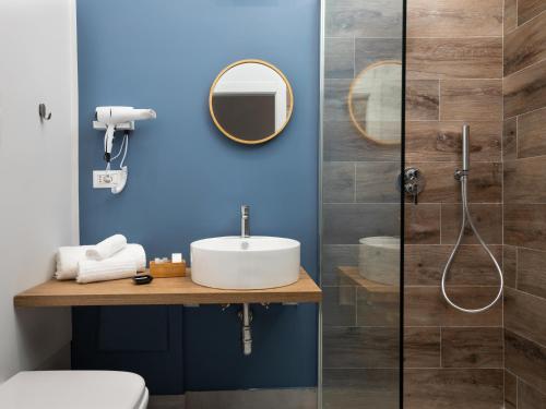 een badkamer met een wastafel en een blauwe muur bij Nartè Rooms in Napels