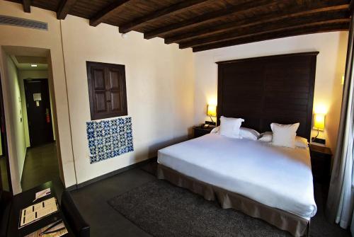 a bedroom with a large white bed in a room at Hotel Convento Aracena & SPA in Aracena