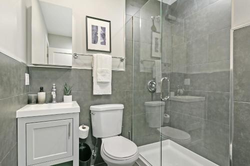 a bathroom with a shower and a toilet and a sink at 2BR Comfy and Stylish Apt in West Town - Erie 1R in Chicago