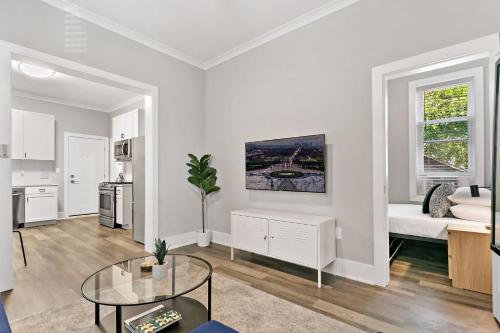 a white living room with a table and a kitchen at 2BR Comfy and Stylish Apt in West Town - Erie 1R in Chicago