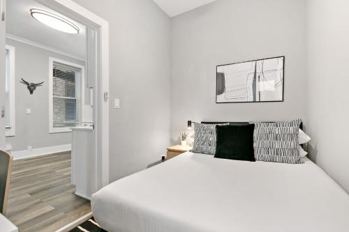 a white bedroom with a large bed and a window at 2BR Comfy and Stylish Apt in West Town - Erie 1R in Chicago