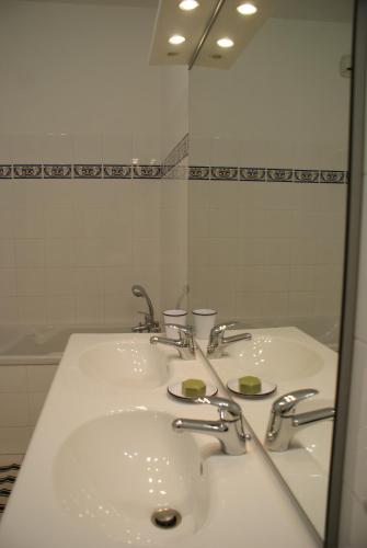 une salle de bain avec deux lavabos et un grand miroir dans l'établissement Le Relais des Négociants, à Saint-Jean-de-Losne