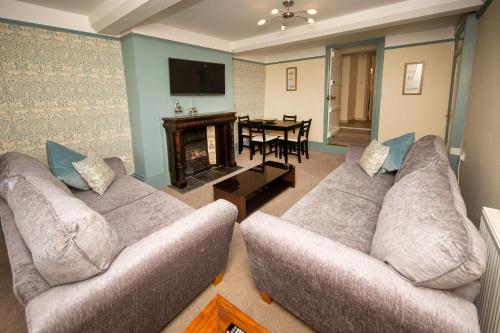 a living room with two couches and a fireplace at The Burrow in Chideock