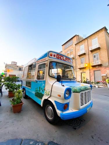 a blue and white bus parked on a street at Appartamento Porto Marina S G 2 in Licata