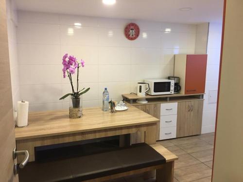 a kitchen with a table with a vase of purple flowers at Pension Luna in Hildesheim