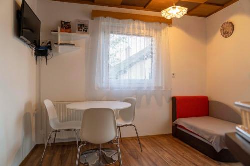 Habitación pequeña con mesa, sillas y cama en Apartma Vražič, en Bled
