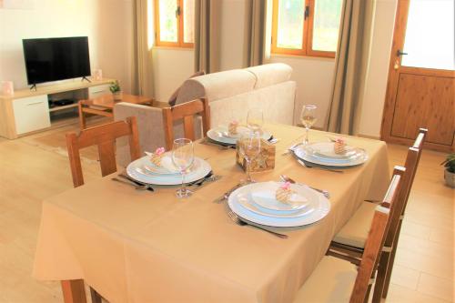 a dining room table with plates and glasses on it at Quinta das Alfambras in Aljezur