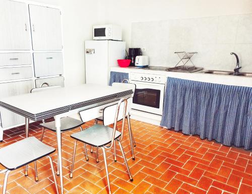 kuchnia z białymi urządzeniami oraz stołem i krzesłami w obiekcie Casa de la Marina w mieście Navas de Oro