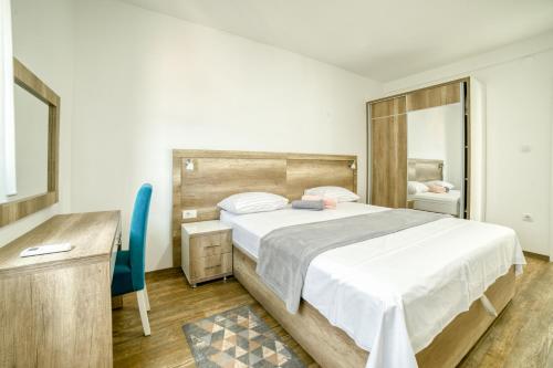 1 dormitorio con cama, escritorio y silla en Obala, en Tivat