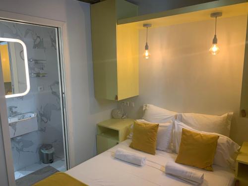 - une chambre avec un lit doté d'oreillers jaunes et d'un miroir dans l'établissement Paris 6 SAINT GERMAIN SEINE, à Paris