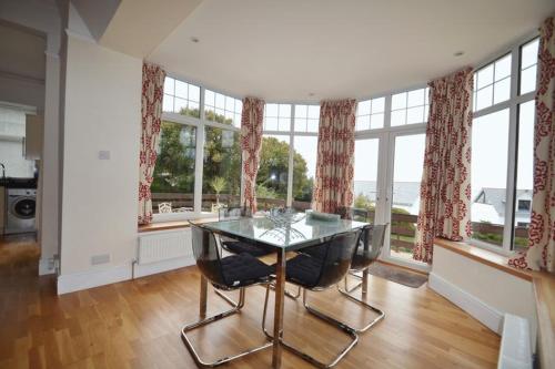 a living room with a table, chairs and a window at Rosemorran Holiday Apartments in St Ives