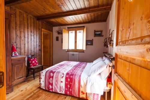 una camera con un letto in una stanza con pareti in legno di B & B La Guiette a Casteldelfino