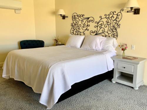 a bedroom with a white bed and a chair at Annie's Place Bed & Breakfast in Boulder Town