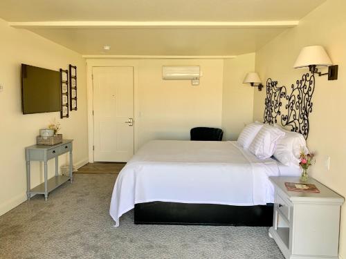 a bedroom with a white bed and a television at Annie's Place Bed & Breakfast in Boulder Town