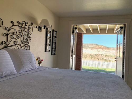 a bedroom with a large bed and a large window at Annie's Place Bed & Breakfast in Boulder Town