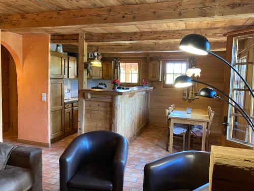a kitchen with a table and chairs and a lamp at La Ferme Des Favrays in Notre-Dame-de-Bellecombe