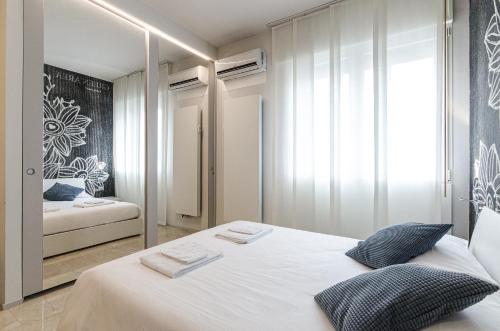 - une chambre avec un lit blanc et un miroir dans l'établissement Residenza l'oasi, à Bologne