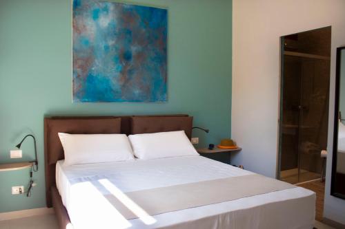 a bed in a bedroom with a painting on the wall at Relais Villa Montedonzelli in Naples