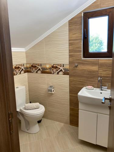 ein Badezimmer mit Toilette und Waschbecken in der Unterkunft Guest House Costa 1 in Karianí