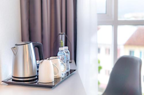 a tray with coffee makers and bottles on a window sill at Kingston Hotel 13 - Penang Hills formerly known as Deview Hotel in Ayer Itam